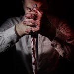bloodthirsty killer posing with a bloody knife pointing down - scarlett bell series